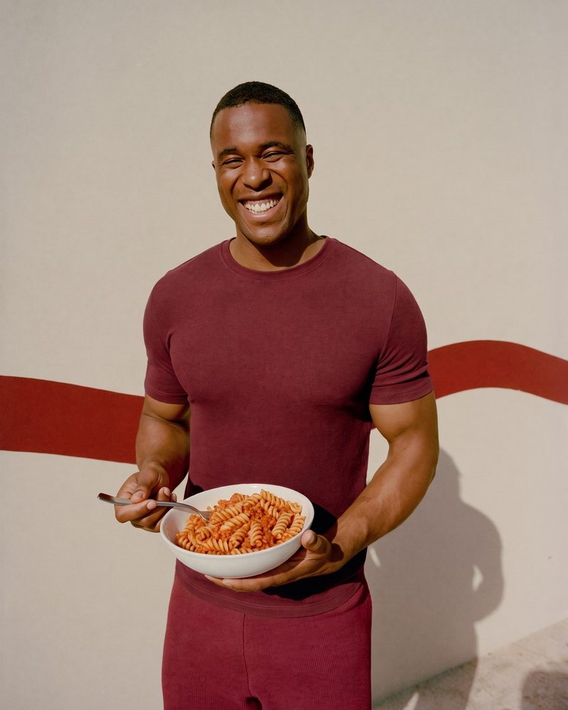 Un uomo sorridente con un piatto di pasta